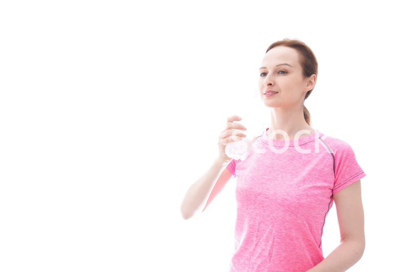 水分補給をするスポーツウェアを着た若い女性