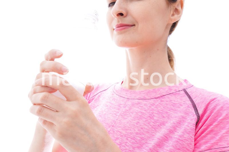 水分補給をするスポーツウェアを着た若い女性