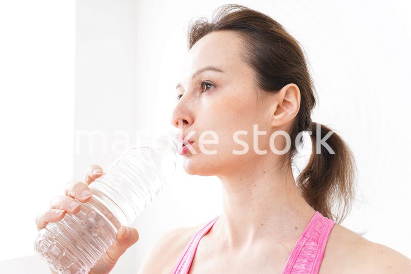 スポーツウェアを着て水分補給をする外国人の女性