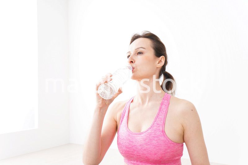 スポーツウェアを着て水分補給をする外国人の女性