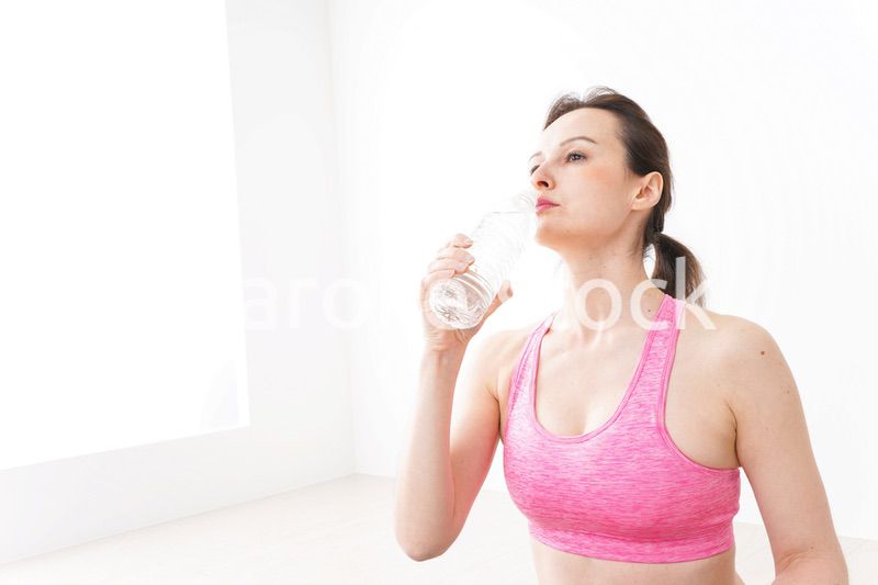 スポーツウェアを着て水分補給をする外国人の女性