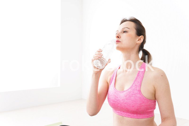 スポーツウェアを着て水分補給をする外国人の女性