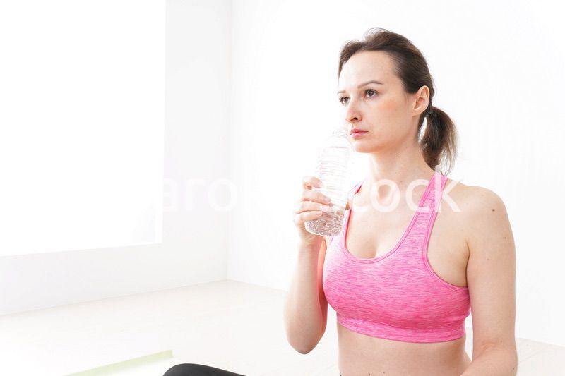 スポーツウェアを着て水分補給をする外国人の女性