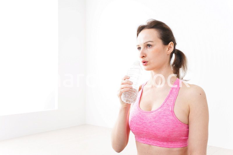 スポーツウェアを着て水分補給をする外国人の女性