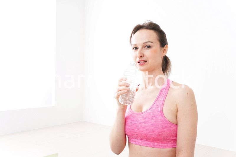 スポーツウェアを着て水分補給をする外国人の女性
