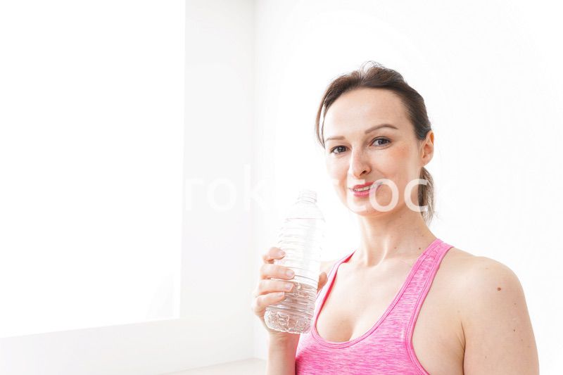 スポーツウェアを着て水分補給をする外国人の女性