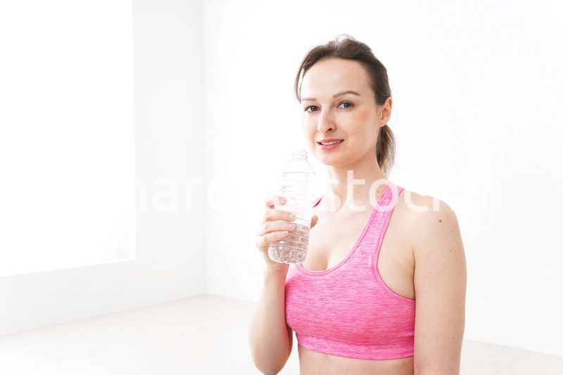 スポーツウェアを着て水分補給をする外国人の女性