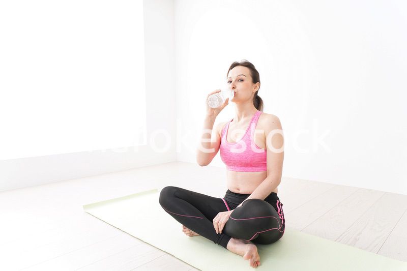 スポーツウェアを着て水分補給をする外国人の女性