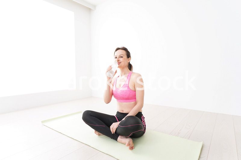 スポーツウェアを着て水分補給をする外国人の女性