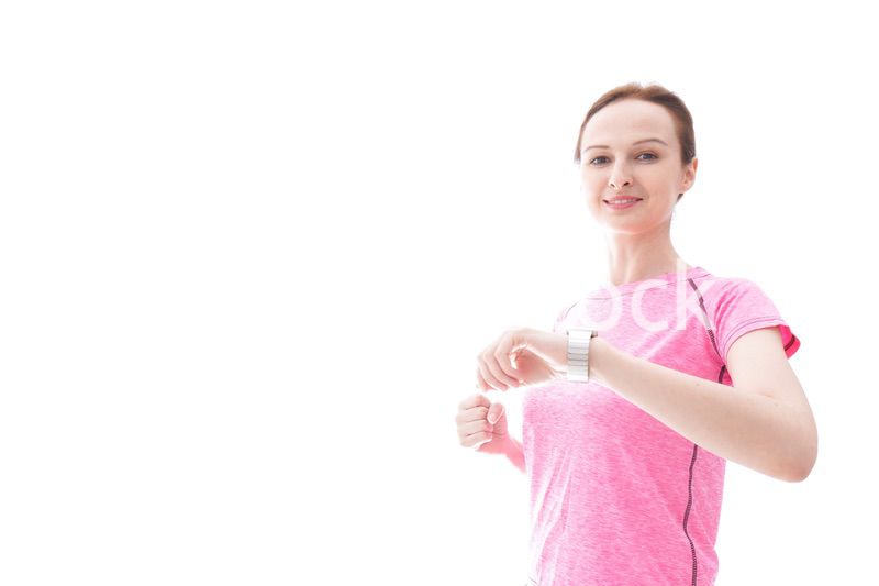 スマートウォッチを確認するスポーツウェアを着た若い女性