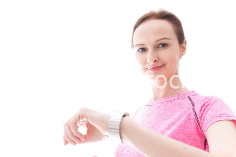 スマートウォッチを確認するスポーツウェアを着た若い女性