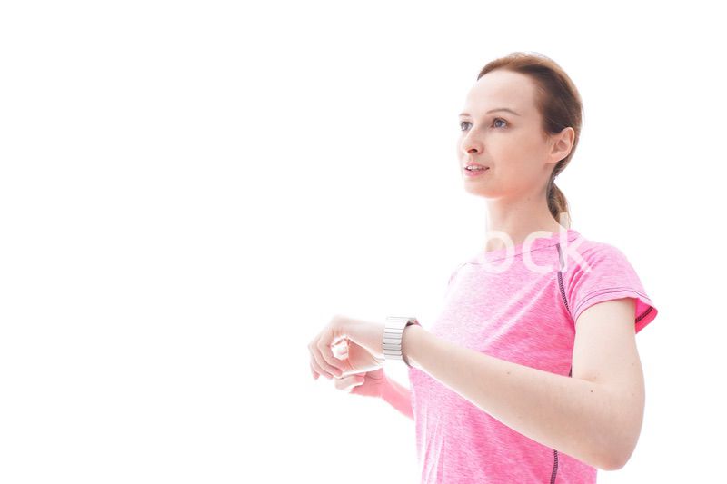 スマートウォッチを確認するスポーツウェアを着た若い女性