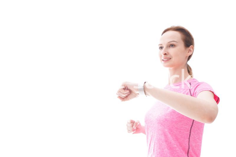 スマートウォッチを確認するスポーツウェアを着た若い女性