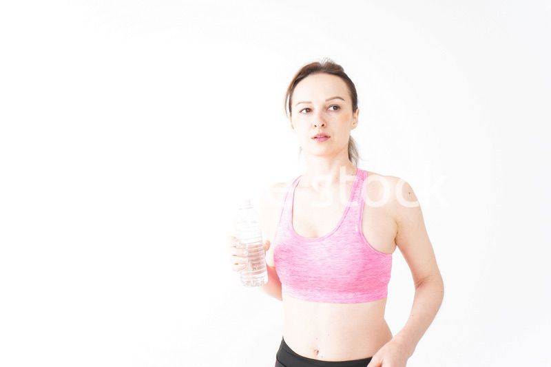 スポーツウェアを着て水分補給をする外国人の女性