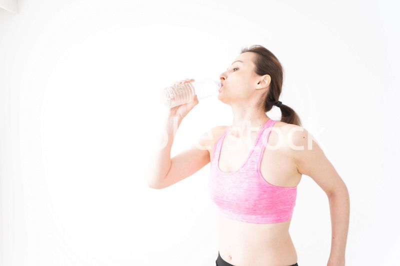 スポーツウェアを着て水分補給をする外国人の女性