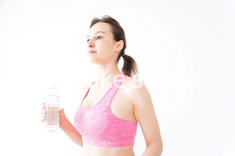 スポーツウェアを着て水分補給をする外国人の女性