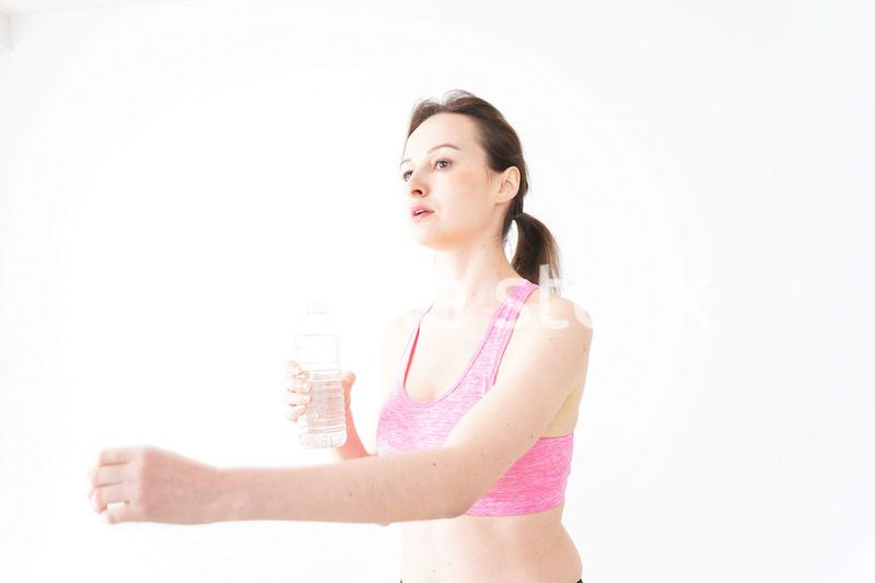 スポーツウェアを着て水分補給をする外国人の女性