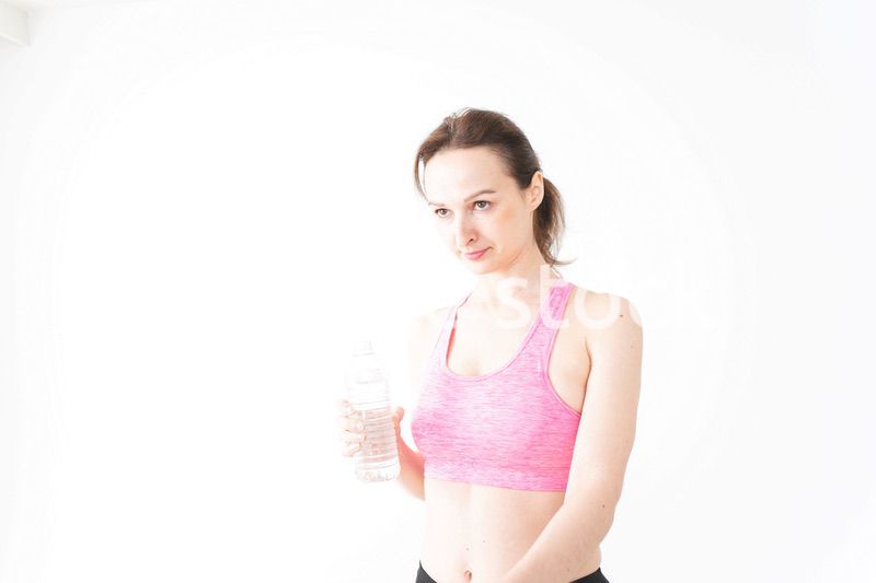 スポーツウェアを着て水分補給をする外国人の女性