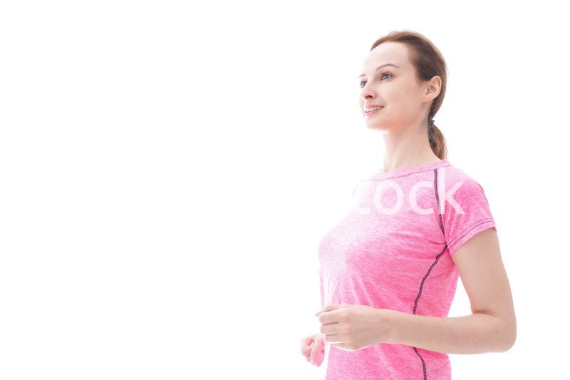 ランニングをする笑顔の若い女性