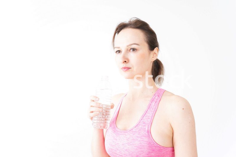 スポーツウェアを着て水分補給をする外国人の女性