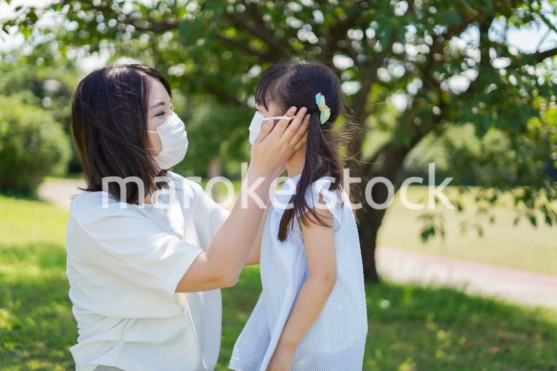 子どもにマスクを付けさせるお母さん