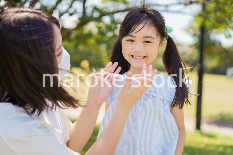 子どもにマスクを付けさせるお母さん