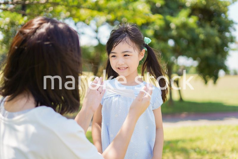 子どもにマスクを付けさせるお母さん