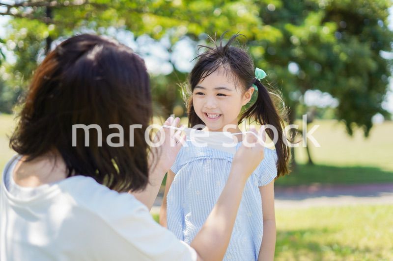 子どもにマスクを付けさせるお母さん