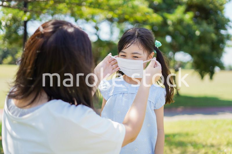 子どもにマスクを付けさせるお母さん