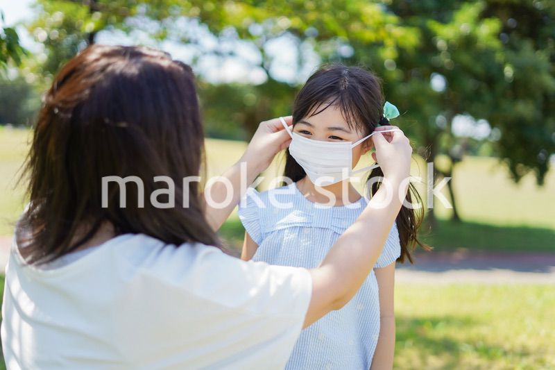 子どもにマスクを付けさせるお母さん