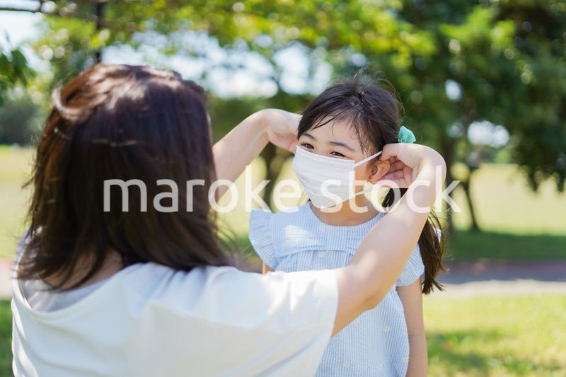 子どもにマスクを付けさせるお母さん