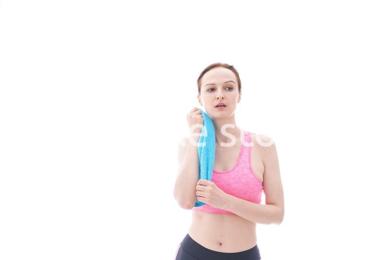 汗を拭くスポーツウェアを着た若い女性