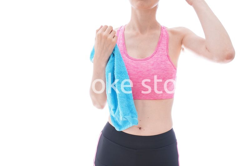 汗を拭くスポーツウェアを着た若い女性