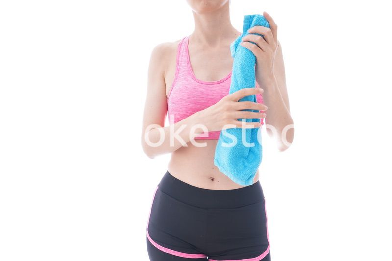 汗を拭くスポーツウェアを着た若い女性
