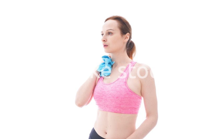 汗を拭くスポーツウェアを着た若い女性