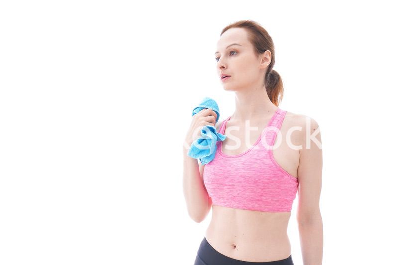 汗を拭くスポーツウェアを着た若い女性