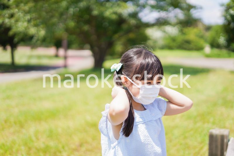 マスクをして暑さに苦しむ子供
