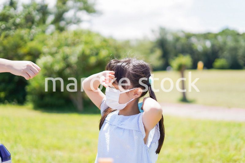 マスクをして暑さに苦しむ子供
