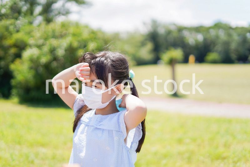 マスクをして暑さに苦しむ子供
