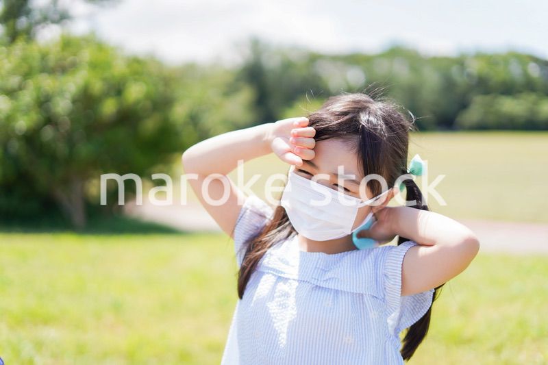 マスクをして暑さに苦しむ子供