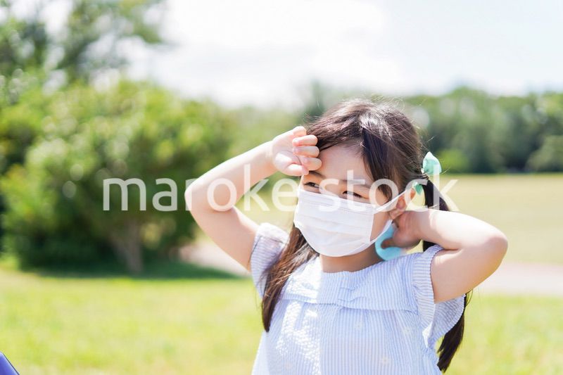 マスクをして暑さに苦しむ子供