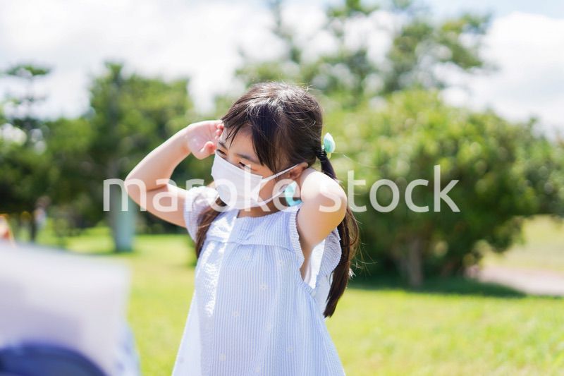 マスクをして暑さに苦しむ子供