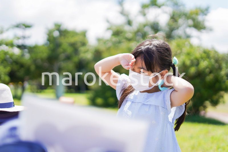 マスクをして暑さに苦しむ子供