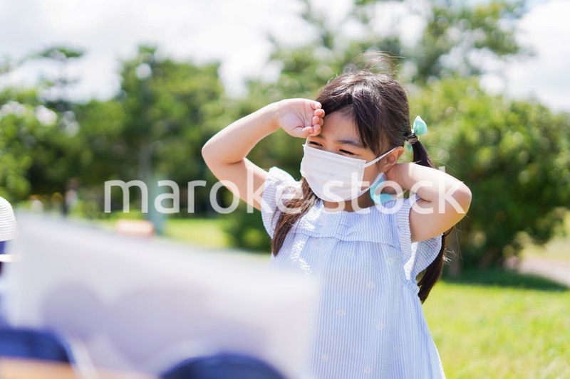 マスクをして暑さに苦しむ子供