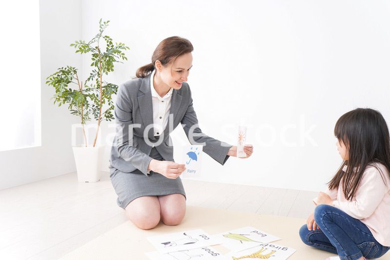 英語教室でネイティブ教師の授業を受ける子ども