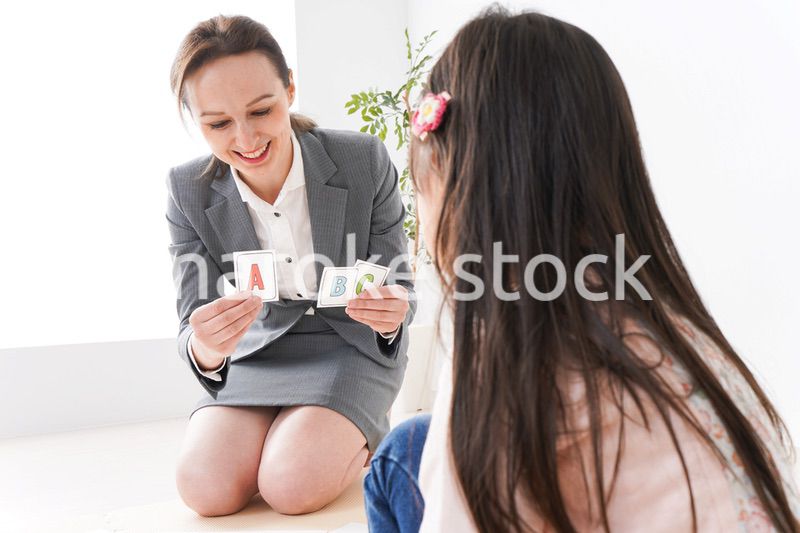 英語教室でネイティブ教師の授業を受ける子ども