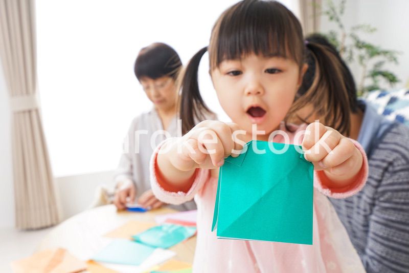 折り紙で遊ぶ子供と家族