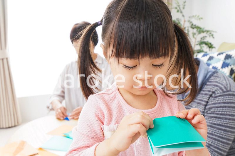 折り紙で遊ぶ子供と家族