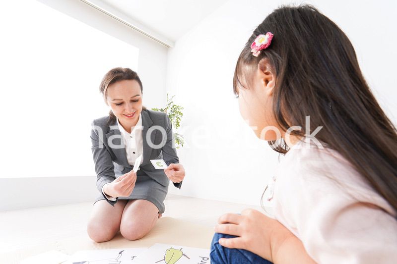 英語教室でネイティブ教師の授業を受ける子ども