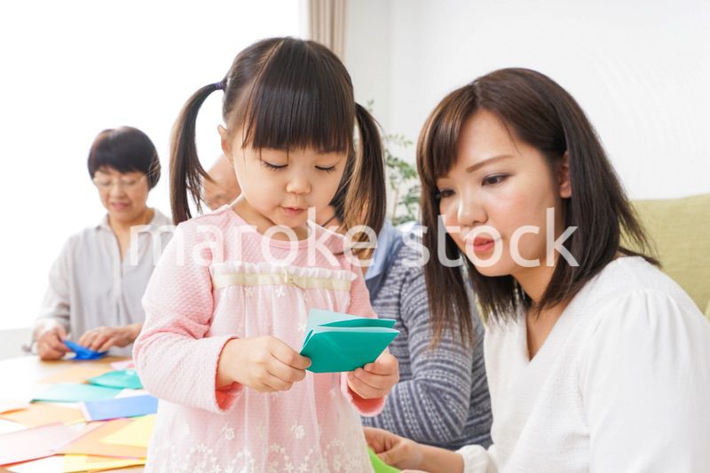 折り紙で遊ぶ子供と家族